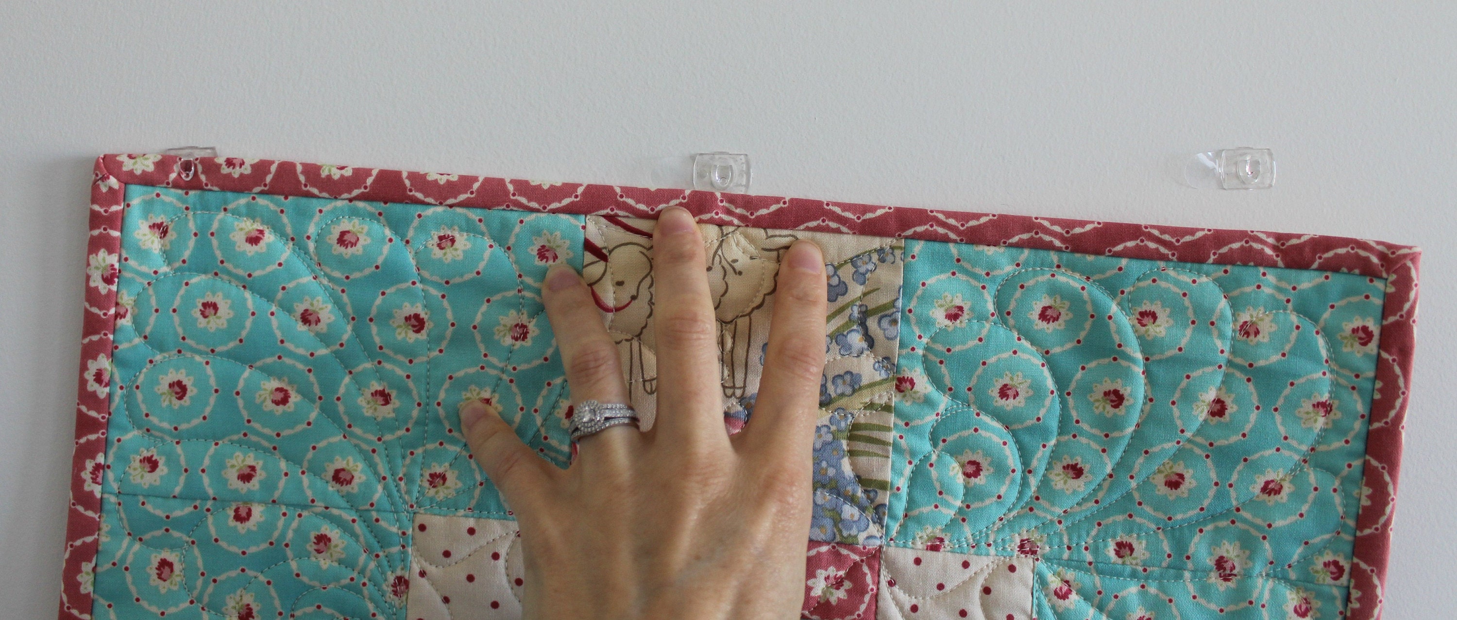 Slide the quilt into the hooks that are turned upside down and voila! Your quilt is hanging!