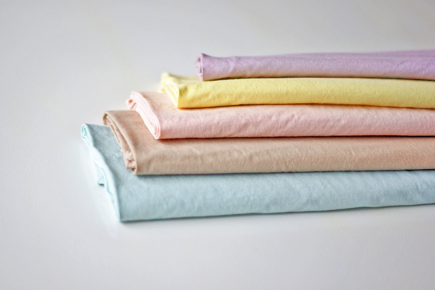 Natural dyes in pastel shades of aqua, beige, pink, yellow and purple.