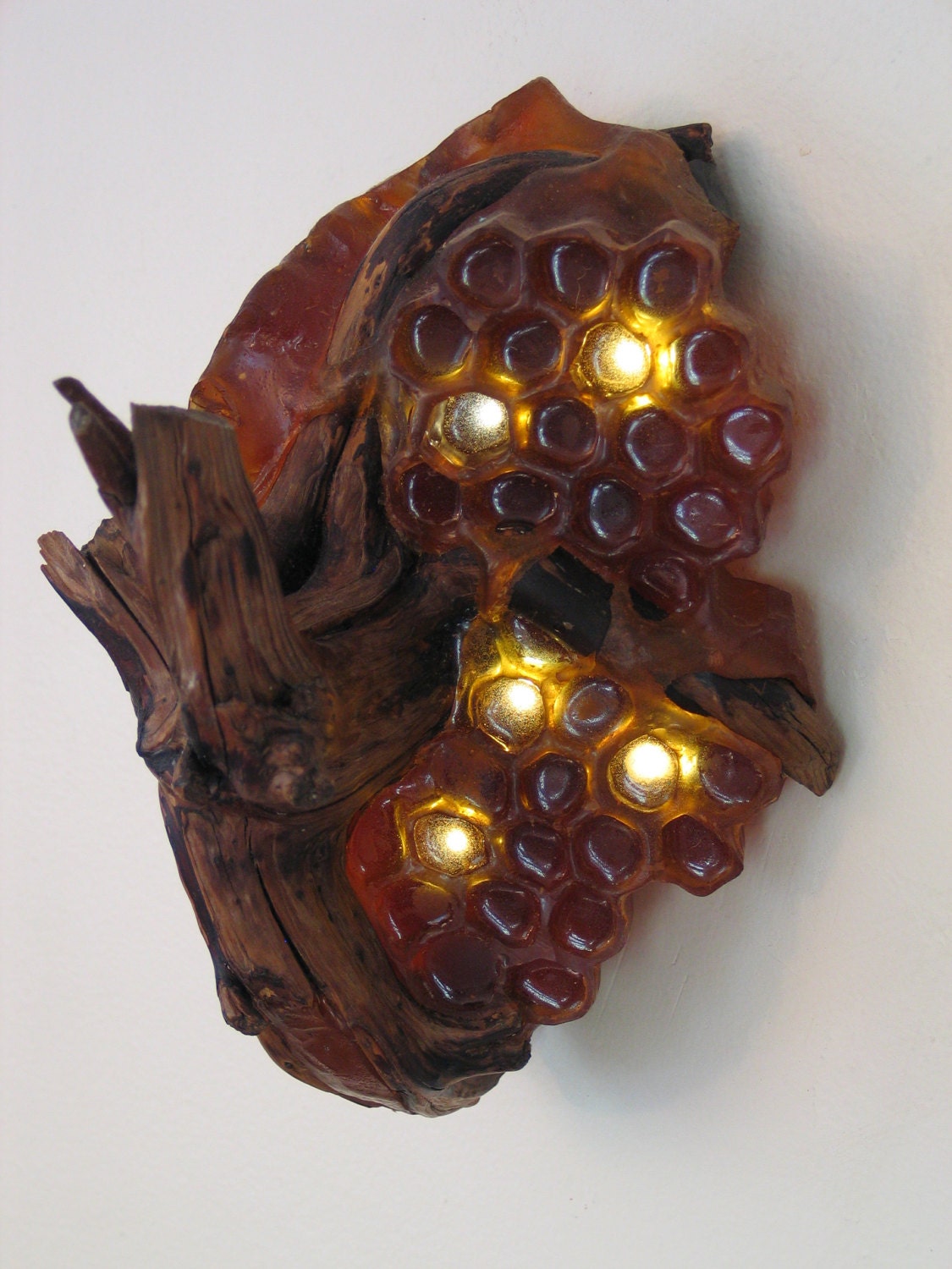 Translucent amber honeycomb with embedded LEDs built around a tree root. Apis habilis: Honeycomb Number 7